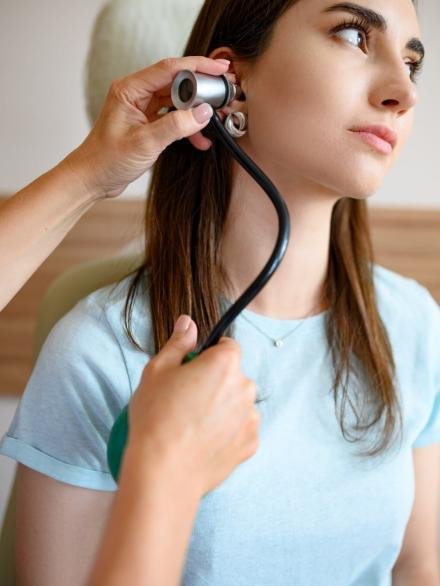 female-ent-doctor-with-otoscope-patient-in-chair-2021-08-29-00-32-48-utc-min