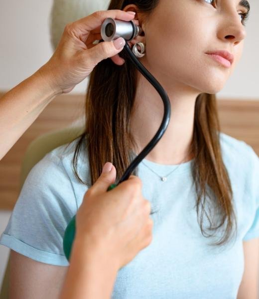 female-ent-doctor-with-otoscope-patient-in-chair-2021-08-29-00-32-48-utc-min